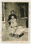 Margert Seefreund holds her daughter Suzanne standing in her baby carriage.