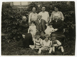Group portrait of four generations of the Juengster family, seated outside in a garden.