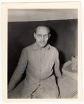 Dr. Carl Hermann sits on bed in Halle Jail.

Caption reads: "Dr.