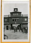 American soldiers and survivors mingle by the entrance to the Buchenwald concentration camp following liberation.