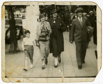 Mark Steil walks down a street in Antwerp with his parents, Adolf and Eliza Steil, and another woman.