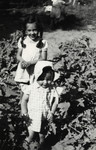 Noemi Cassuto and her little brother Ariel play outdoors in some bushes.