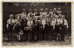 Group portrait of children from the public school in Brasov Romania holding bouquets of flowers.