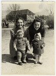Two young women pose with their toddlers at the Eschwege displaced persons' camp.