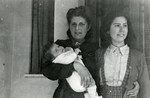 Luba Spiegelglass Fainas holds her newborn son Georges while standing next to her older daughter Renee.