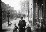 Hartog Kisch walks down the street with his two grandsons Eldad and Hanan .