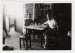 Gertrud and Alfred Heller sit at a table inside the Shanghai Jewish Community Center.