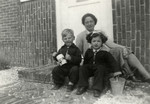 Hanan Kisch sits on the stoop of a building with his cousin Lin de Bruin and her daughter.