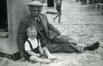 Hanan Kisch sits next to a beach cabana with his grandfather, Hartog Kisch.