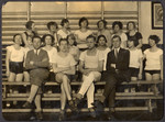 Members of a Deaf gymnastics club pose for a group portrait on the bleachers.