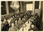 Members of the Jewish Brigade gather at set tables for a festive meal.