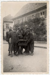 Jewish survivors from Kaufering I carry a crate of bottles right after their liberation by the American army.