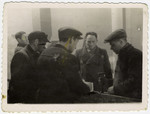A group of Jewish men discuss their work in one of the Lodz ghetto workshops.