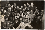 Group portrait of members of a theater group, some in costume, in the Lodz ghetto.