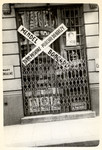 View of a boarded up store in besieged Warsaw.  The sign outside reads: "A black marketeer was here - He went to Bereza-Kartuska." 

Bereza - Kartuska was a Polish prison for political criminals that operated from 1934-1939.