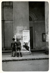 Polish boys look at Polish anti-Nazi propaganda pasted onto columns in besieged Warsaw.