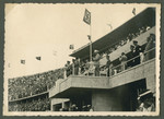 Adolf Hitler watches the ceremonies from his reviewing stand in the Olympic stadium.