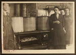 The kitchen staff of the Jewish Refugee Aid Committee of Antwerp stands by three large pots.
