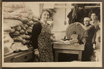 Kitchen workers of the Jewish Refugee Aid Committee of Antwerp slice large loaves of bread.