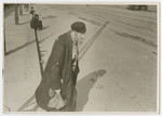 An impoverished Jewish man walks down a street in Poland.