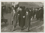 A group of religious Jews walk down a street in Karkow.