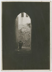 View of a religious Jews walking through an archway and down a flight of steps [possibly in Jerusalem].