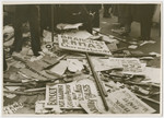 A pile of protest signs about an anti-Nazi boycott lie on the ground.