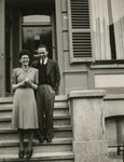 Femia van West and her fiance pose on the steps of a building.