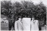 David Klinger pictured (on right) with his cousin Motek Weingarten pose by the tombstone of Joel Klinger.