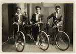 Studio portrait of three young men with their bicycles.