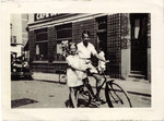 Eva and Heinz Geiringer pose with a bicycle on a street in Belgium after fleeing Vienna.