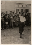 A crowd gathers aroung a street performer in the Lodz ghetto.