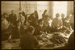 Workers iron and sew in one of the textile factory in the Lodz ghetto.