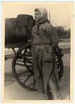 Close-up photograph of a female "fecalist", standing next to a sewage cart in the Lodz ghetto.