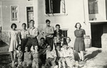 Group portrait of Jewish youth [probably either a school group or Betar] stand outside a building wearing Jewish stars.