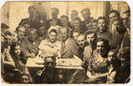 A group of friends gather for a celebration [possibly a wedding] in the Deggendorf displaced persons' camp.