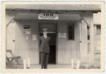 Eliezer Freedman stands outside the administrative building of the Hallein displaced persons' camp.