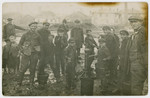 Men and boys gather by a water pump in the main square [probably of Borislav.]
