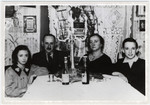 The Megdal family sits around a Sabbath table with challah, wine and candles shortly before the start of World War II.