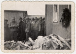 American soldiers examine the pile of corpses outside the Buchenwald crematorium.