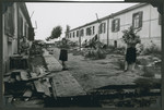 Women walk past debris strewn on a street in the Ziegenhain displaced persons camp.