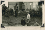 Men and children stand outside a building in the Ziegenhain displaced persons camp.
