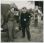Two Jewish policemen in the Zeilsheim displaced persons camp stand next to a truck.