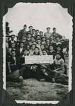 Group portrait of members of the Mizrachi religious Zionist youth movement in the Ziegenhain displaced persons' camp holding a sign that reads, "Our eternity is in Torah, our task is in work."

Two members of the Frankfurt GI Council pose with them in the back row.