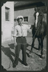 Close-up portrait of a man holding a horse in the Hafetz Hayyim religious kibbutz in the Zeilsheim displaced persons camp.
