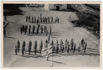 Cadets at an officer training course stand in formation in front of a flag at a Haganah training camp.