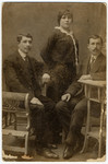 Studio portrait of Leja Blecher standing between her two brothers in Kelme Lithuania.