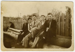 The Luksenburg family poses on some large logs shortly before the start of World War II.
