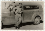 Julius Menn, an soldier in the Israeli army, stands next to an automobile marked "State of Israel".