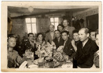 A group of displaced persons sits around a table in Zeilsheim following  a memorial service for victims of the Holocaust.
